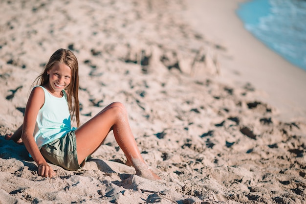 Petite Fille Sur La Plage Joue Avec Du Sable Au Coucher Du Soleil