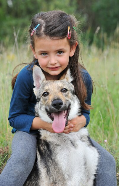 Petite Fille Et Son Bebe Chien Loup Photo Premium