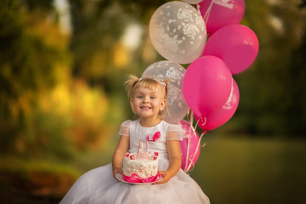 Petite Fille Tenant Un Gateau D Anniversaire Avec Des Ballons Espace Copie Photo Premium