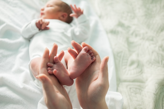 Petits Pieds De Bebe Dans Les Mains Maternelles Photo Premium