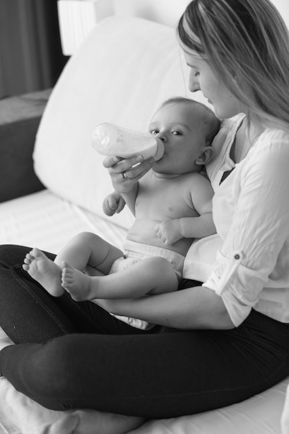 Photo En Noir Et Blanc De La Belle Mere Nourrissant Son Bebe Sur Le Lit Photo Premium