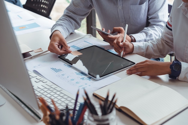 Photo recadrée des concepteurs frontaux de démarrage de l'interface utilisateur ux ui qui dessinent du contenu web réactif ou une application mobile avec des concepteurs graphiques de tablet.ux. ils ont dessiné un prototype et une disposition filaire. Photo Premium