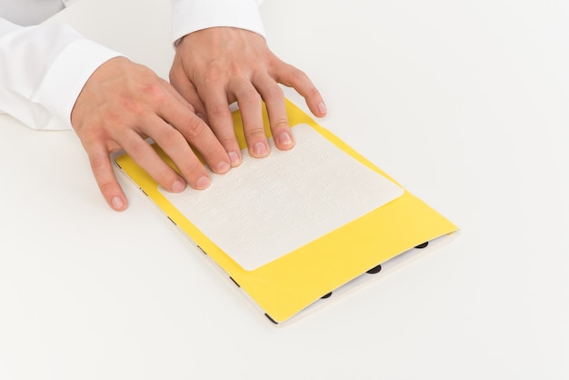 Photo recadrée des mains d'un homme qui lit le braille Photo Premium