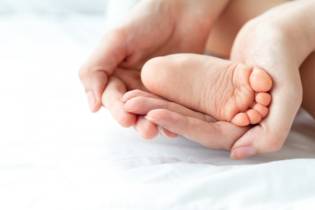 Le Pied De Bebe Est Entre Les Mains De La Mere Photo Gratuite