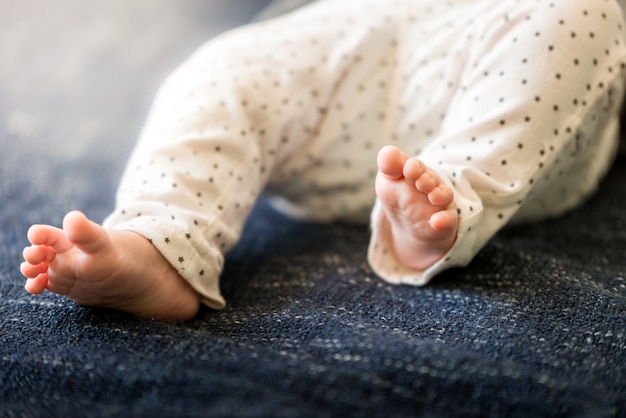 Pieds Mignons Bebe Nouveau Ne Sur Une Couverture Bleue Se Bouchent Dans L Enfance De Pantalon Photo Premium