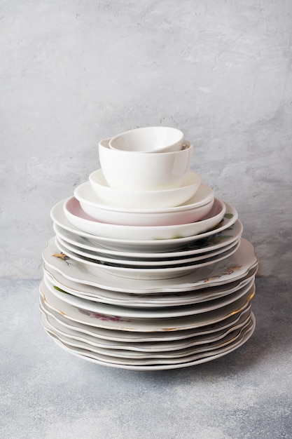 Pile d'assiettes propres vides sur une table grise avec espace de copie. Photo Premium