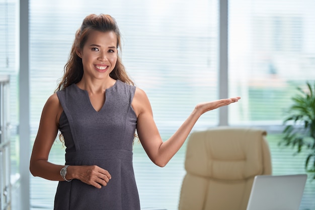 Plan moyen d'un modèle asiatique gesticulant comme s'il présentait un produit dans une publicité Photo gratuit
