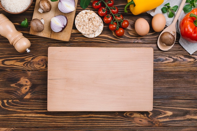 Planche A Decouper En Bois Blanc Avec Crudites Et Gateau De Riz Souffle Sur Le Bureau En Bois Photo Gratuite