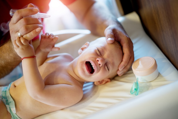 Pleurer Un Beau Bebe Enfant Couche Sur Le Mauvais Avec Une Tetine Et De La Creme Pres De La Tete Et Rejeter Pour Obtenir Des Gouttes Nasales Photo Premium