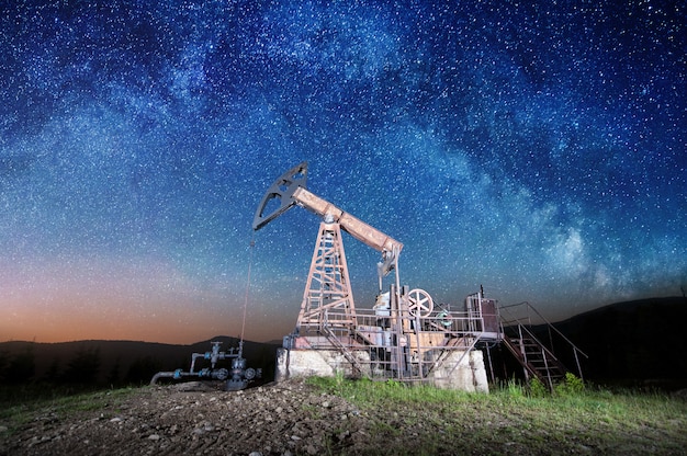 Pompe à huile sur le champ de pétrole dans la nuit | Télécharger des Photos Premium