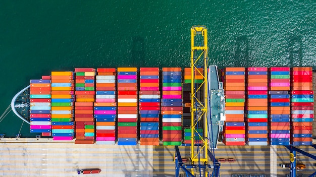 Porte-conteneurs de chargement et de déchargement dans le port de haute mer, vue de dessus aérienne d'import / export de logistique d'entreprise Photo Premium