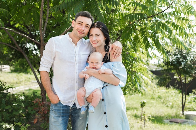 Portrait D Aimer Jeune Couple Avec Leur Bebe Debout Dans Le Parc Photo Gratuite