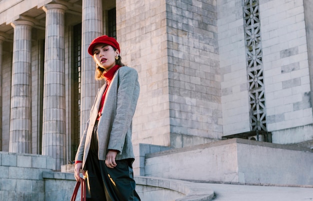 Portrait, de, a, beau, jeune femme, dans, casquette rouge, debout, devant, ancien, bâtiment Photo gratuit