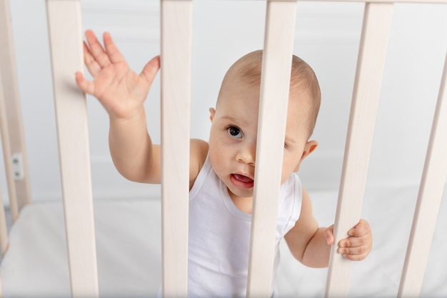 Portrait D Un Bebe Garcon De 8 Mois Debout Dans Un Berceau Dans Une Chambre D