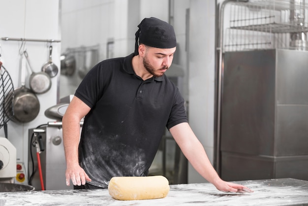 Portrait d'un chef pâtissier dans la cuisine prêt à pétrir la pâte. Photo Premium