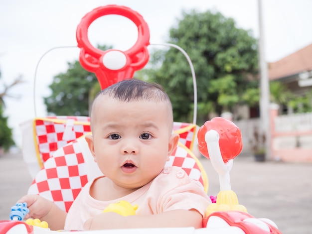 Portrait Enfant Petit Garcon 9 Mois Assis Dans Le Marcheur De Bebe Sur Le Parc Flou Photo Premium