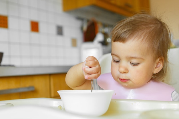 Portrait D Un Enfant Qui Mange De La Nourriture Pour Bebe Avec Sa Cuillere Mon Visage Est Enduit De Nourriture Photo Premium