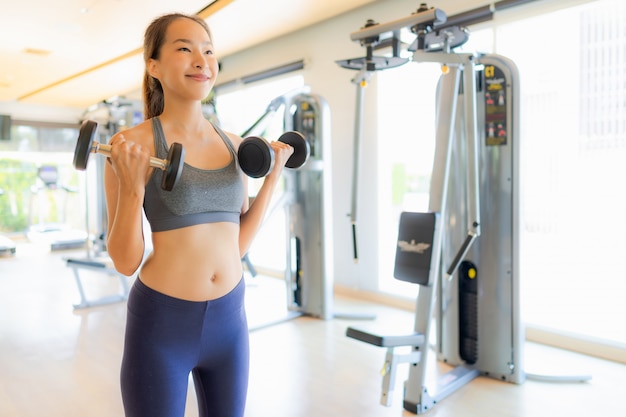 Portrait femme asiatique exerçant et entraînez-vous dans une salle de sport Photo gratuit