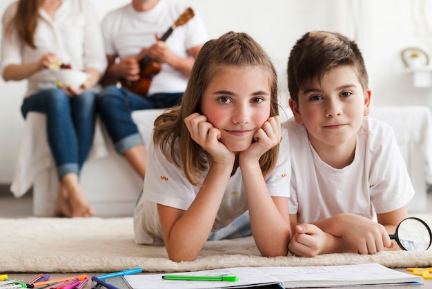 Portrait, frère, regarder appareil-photo, devant, parent, s'asseoir lit Photo gratuit