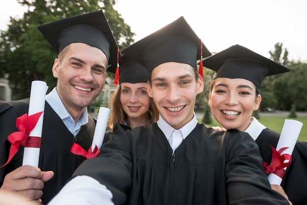 Portrait d'un groupe d'étudiants célébrant leur remise des diplômes Photo gratuit