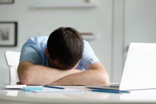 Portrait D un Homme Couch Sur Le Bureau Pr s De L ordinateur Portable portrait-d-un-homme-couch-sur-le-bureau-pr-s-de-l-ordinateur-portable