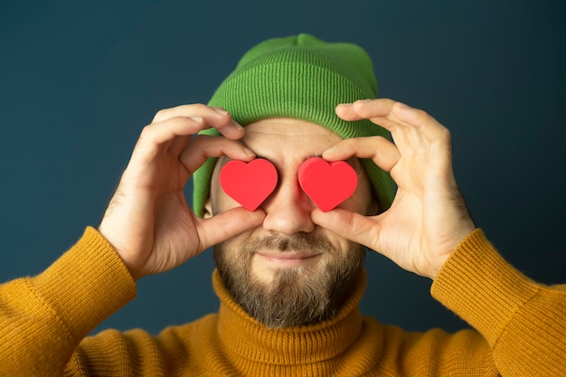 Portrait D Un Homme Joyeux Jeune Hipster Drole Avec Un Cœur Dans Ses Yeux Sur Un Fond Bleu Photo Premium