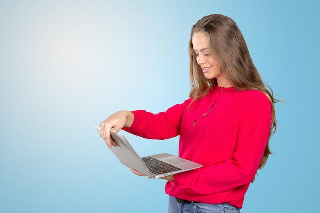 Portrait d'une jeune femme souriante debout avec un ordinateur portable Photo Premium