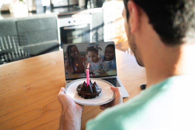 Portrait D Un Jeune Homme Celebrant Son Anniversaire Lors D Un Appel Video Depuis La Maison Avec Un Ordinateur Portable Et Un Gateau Nouveau Concept De Mode De Vie Normal Photo Gratuite