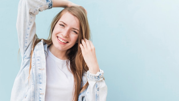 Portrait de jolie femme souriante sur le mur bleu Photo gratuit