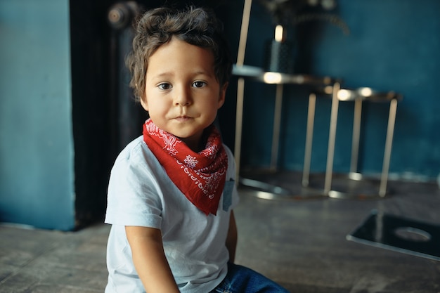 Portrait Of Cute Grassouillet Metis Petit Garcon Aux Cheveux Boucles Et Peau Foncee Assis Sur Le