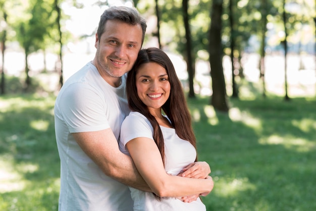 Portrait de sourire couple d'amoureux dans le parc Photo gratuit