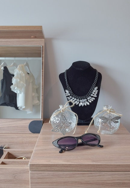 Pots de cristal et collier sur coiffeuse en bois Photo Premium