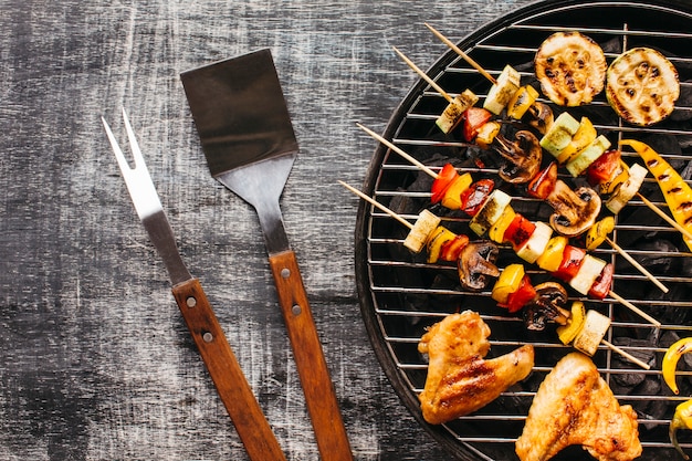 Préparation de la viande grillée sur la grille du barbecue sur fond en bois Photo gratuit