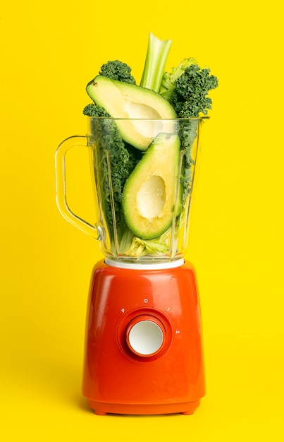 Recette De Smoothie. Smoothie Vert De Légumes (avocat, Céleri, Salade De Cale, épinards) Dans Un Mélangeur Sur Fond Jaune. Concept De Désintoxication Des Aliments Sains Et Végétaliens Photo Premium