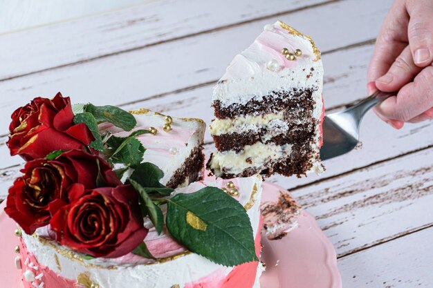 Retirer Une Part De Gateau Au Chocolat Recouverte De Creme Au Beurre A La Meringue Suisse Trois Fleurs Rouges Sur Le Dessus Photo Premium