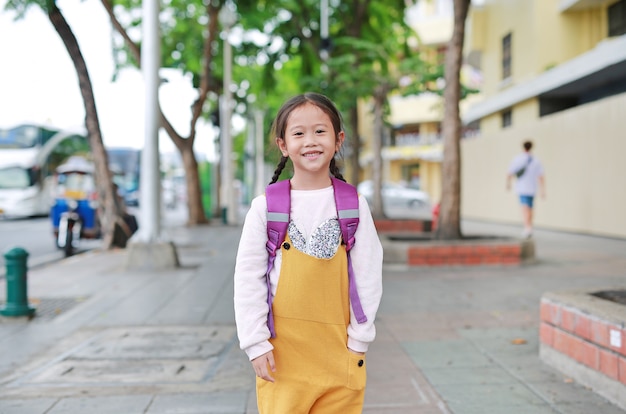 Retour à l'école. fille enfant asiatique heureux avec cartable d'épaule d'étudiant. petite écolière avec un sac à dos. Photo Premium