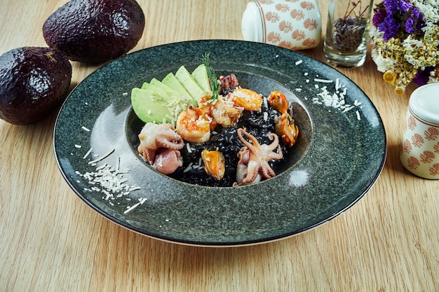 Risotto De Riz Noir Au Parmesan Avocat Et Fruits De Mer Crevettes Bebe Poulpe Et Moules Dans Un Bol Sur Une Table En Bois Nourriture Italienne Nourriture Gastronomique Nourriture Saine Photo