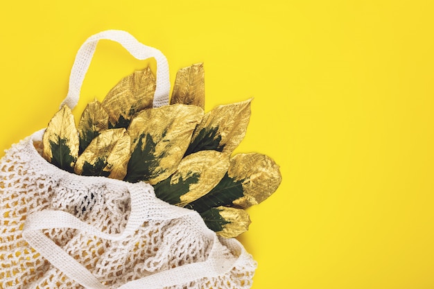 Sac de magasinage réutilisable avec des feuilles vertes et dorées sur fond d'automne automne jaune Photo Premium