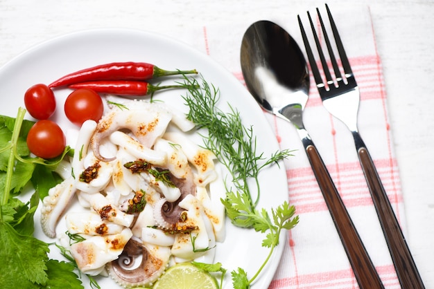Salade de calamars aux herbes de citron et aux épices sur la vue de dessus de table à manger. pieuvre cuit apéritif alimentaire sauce piment fort et épicé. Photo Premium