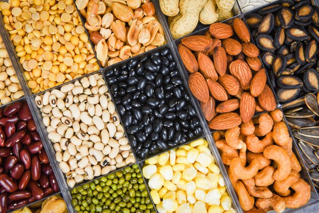 Sélectionnez Différents Grains Entiers Haricots Et Légumineuses Graines Lentilles Et Noix Fond Coloré Snack Vue De Dessus - Collage Divers Haricots Mélanger Les Pois Agriculture D'aliments Naturels Sains Pour La Cuisson Des Ingrédients Photo Premium