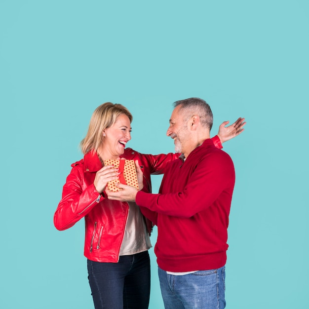 Senior homme donnant une boîte cadeau à sa femme blonde mature gaie Photo gratuit