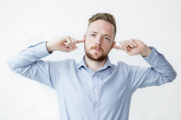 Serious Man Stopping Ears With Fingers | Photo Gratuite