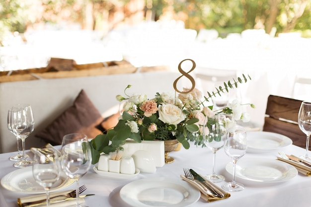 Service de table de mariage décoré de fleurs fraîches dans un vase en laiton. table de banquet pour les invités à l'extérieur Photo Premium