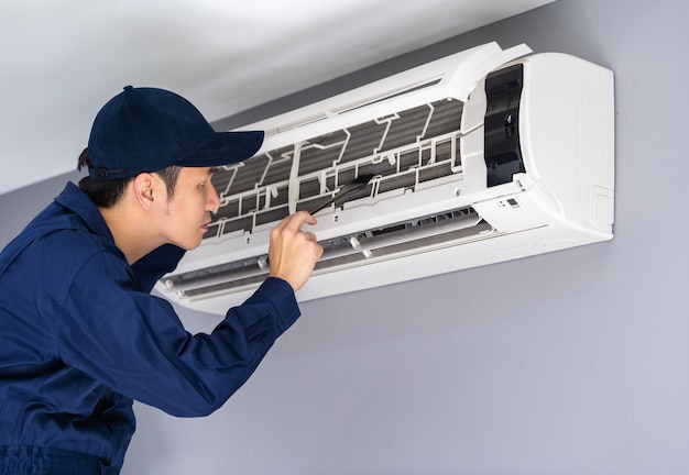 Service technique utilisant une brosse pour nettoyer le climatiseur Photo Premium