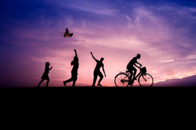 silhouettes-enfants-jouent-cerfs-volants-cyclistes-au-coucher-du-soleil_30457-162.jpg