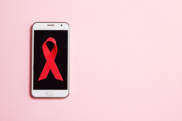 Smartphone avec symbole de sensibilisation au cancer du sein. examen médical et concept de soins de santé féminin. vue de dessus, pose à plat, espace de copie Photo Premium