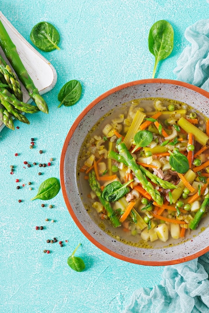 Soupe au bœuf, asperges, pois verts, carottes et céleri. la nourriture saine. lay plat. Photo Premium
