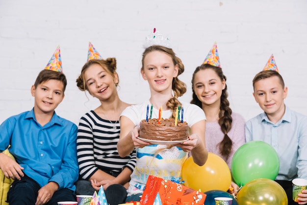 Souriant Portrait D Une Adolescente Assise Avec Ses Amis Tenant Un Gateau D Anniversaire Photo Gratuite