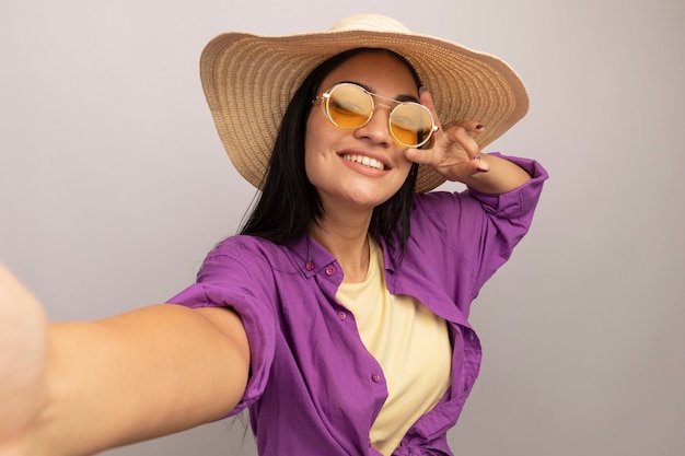 Souriante Jolie Fille Brune Caucasienne à Lunettes De Soleil Avec Chapeau De Plage Gestes Signe 0467