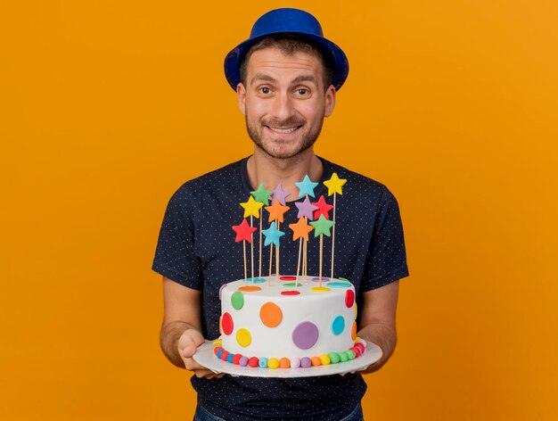 Sourire Bel Homme Portant Un Chapeau De Fete Bleu Detient Un Gateau D Anniversaire Isole Sur Un Mur Orange Avec Espace Copie Photo Gratuite